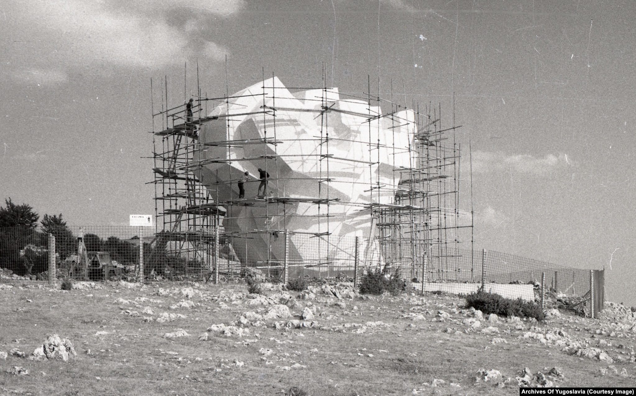 Workers on scaffolding around the angular concrete wings of the Makljen Pass memorial, late 1970s.